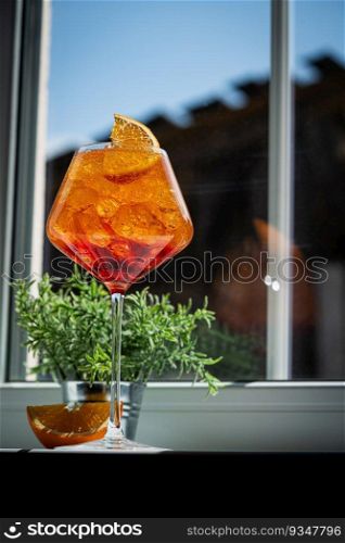 Glass of Aperol spritz cocktail with fresh oranges near the window. natural light and shadows. Glass of Aperol spritz cocktail