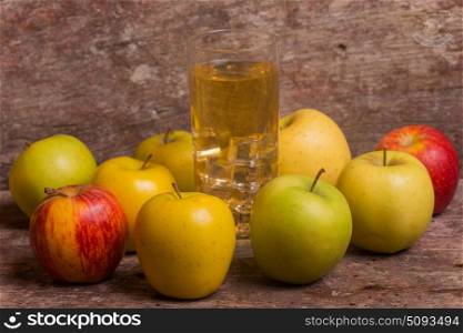 Glass of apple juice and fruits on a old wooden background. apple juice