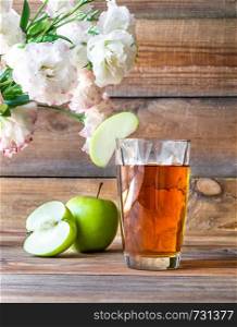 Glass of apple juice with fresh apples on the wooden background