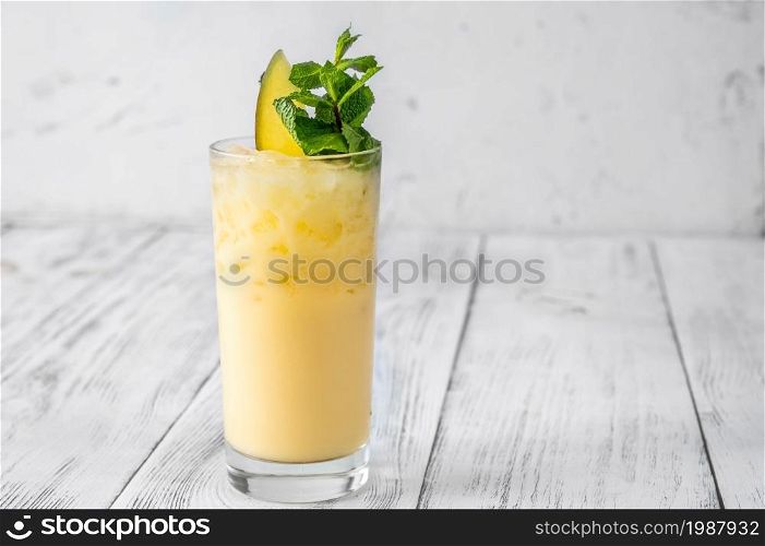 Glass of Batida de Carneval garnished with mango slice and fresh mint