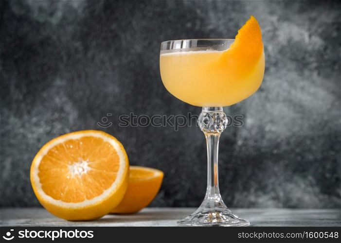 Glass of Bee&rsquo;s Knees cocktail garnished with orange zest