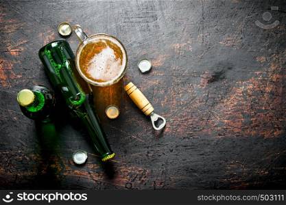 Glass of beer and a bottle. On dark rustic background. Glass of beer and a bottle.