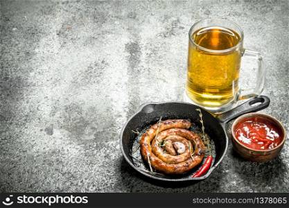 glass of beer with hot sausage. On a rustic background.. glass of beer with hot sausage.