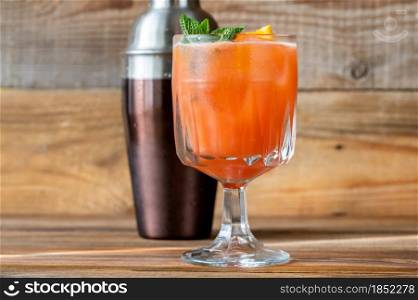 Glass of Belmont Breeze Cocktail garnished with orange slice and fresh mint