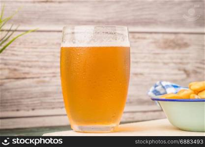 Glass of bier on wooden table top.