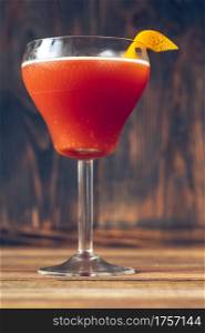 Glass of Blood And Sand Cocktail in martini glass garnished with orange peel