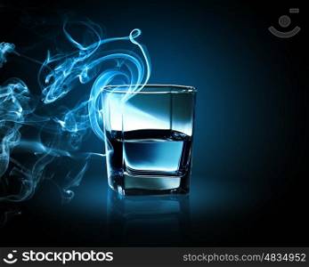 Glass of blue cocktail. Image of glass of blue cocktail with fume going out