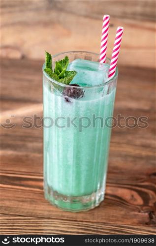 Glass of Blue Hawaiian cocktail on wooden background