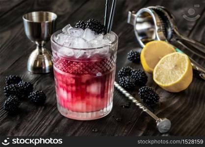 Glass of Bramble cocktail made of gin, lemon juice, sugar sypup and creme de mure