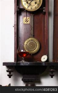 Glass of brandy standing inside an old clock