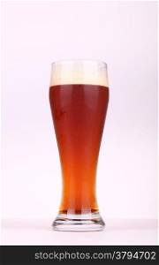 Glass of brown ale over a white background