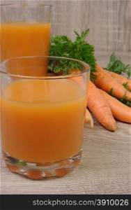 glass of carrot juice on the table with carrots