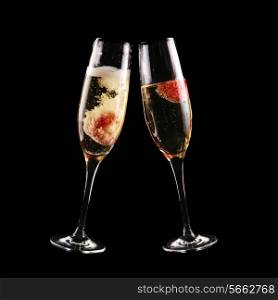 glass of champagne with strawberry on black background