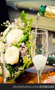 glass of champagne with wedding bouquet