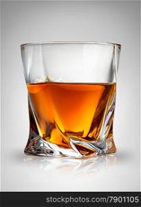 Glass of cognac on a gray background