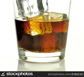 glass of cola with ice cubes close up