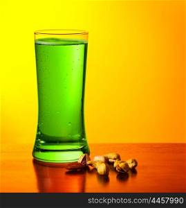 Glass of cold green Irish beer drink isolated on yellow warm background, festival of beer, traditional alcohol for st.Patrick&rsquo;s day holiday celebration, lucky clover beverage, studio food still life