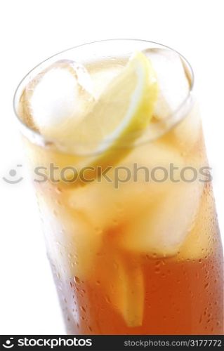Glass of cold iced tea with water drops on surface, focus on the drops