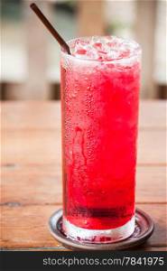 Glass of cold red drink with straw
