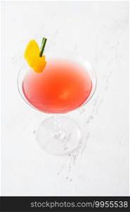 Glass of Cosmopolitan cocktail garnished with a lemon zest