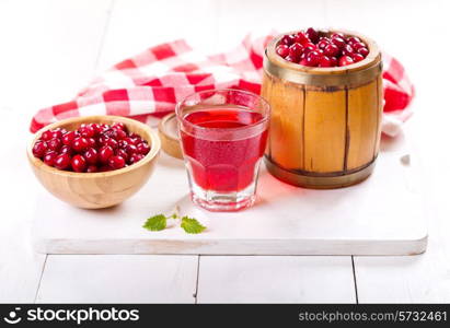 glass of cranberry juice with fresh berries on wooden table