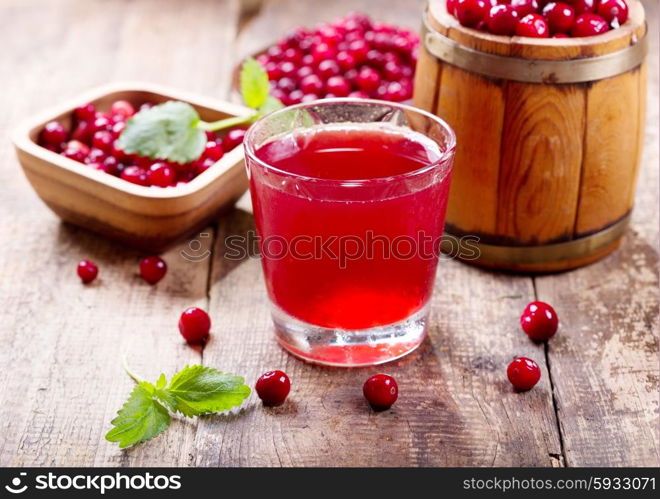 glass of cranberry juice with fresh berries on wooden table