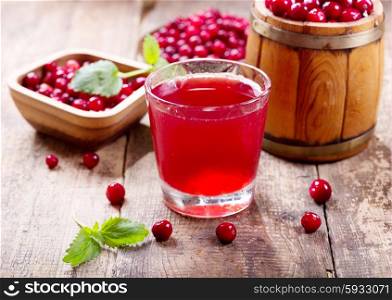 glass of cranberry juice with fresh berries on wooden table