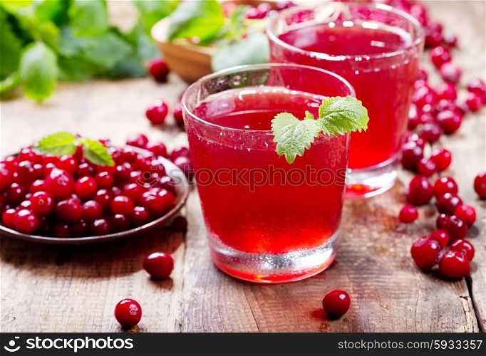 glass of cranberry juice with fresh berries on wooden table