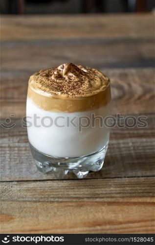 Glass of dalgona coffee on rustic background