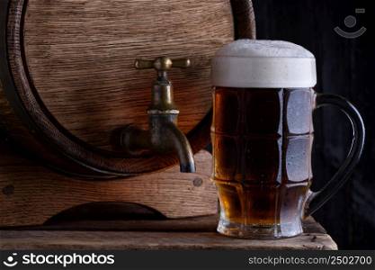 Glass of dark beer with vintage wooden beer barrel still life