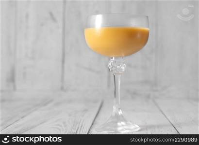 Glass of Eggs-cellent Cocktail on wooden background