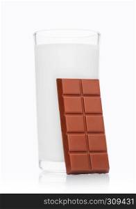 Glass of fresh breakfast milk with chocolate bar on white background