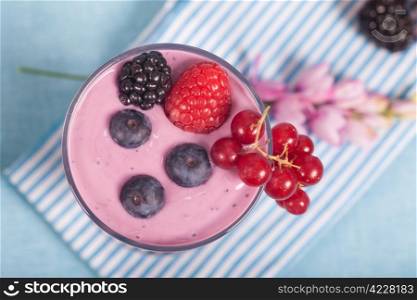 Glass of fresh delicious yogurt with berry fruits