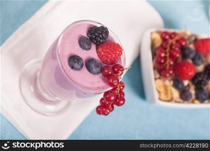 Glass of fresh delicious yogurt with berry fruits