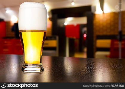 glass of fresh draft lager beer on table in pub