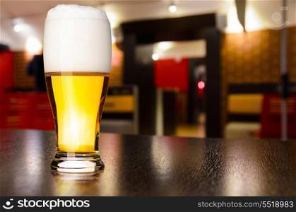 glass of fresh draft lager beer on table in pub. draft beer