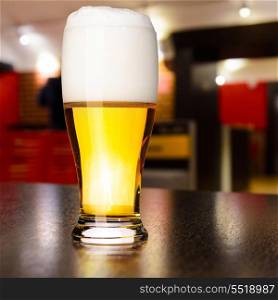 glass of fresh draft lager beer on table in pub. draft beer