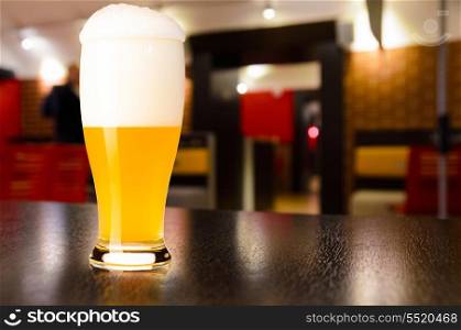 glass of fresh draft weiss beer on table in pub. draft beer