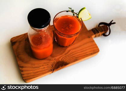 Glass of fresh juice with sliced green apple on wooden board