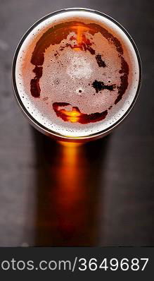 glass of fresh lager beer on black table