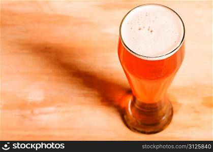 glass of fresh lager beer on wooden table