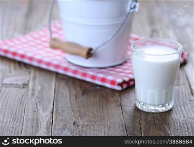 Glass of fresh milk on wooden table in the kitchen.&#xA;