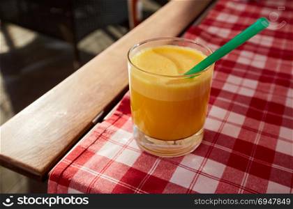Glass of fresh orange juice at summer terrace cafe.. Glass of fresh orange juice at summer terrace cafe