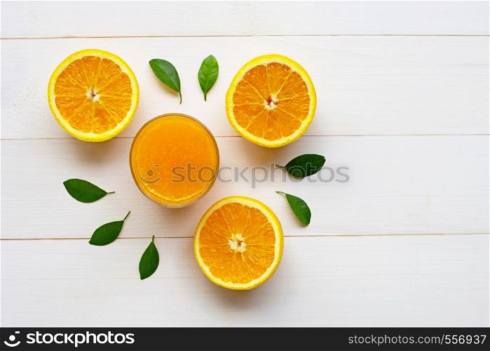 Glass of fresh orange juice with fresh fruits on white wooden background. Top view