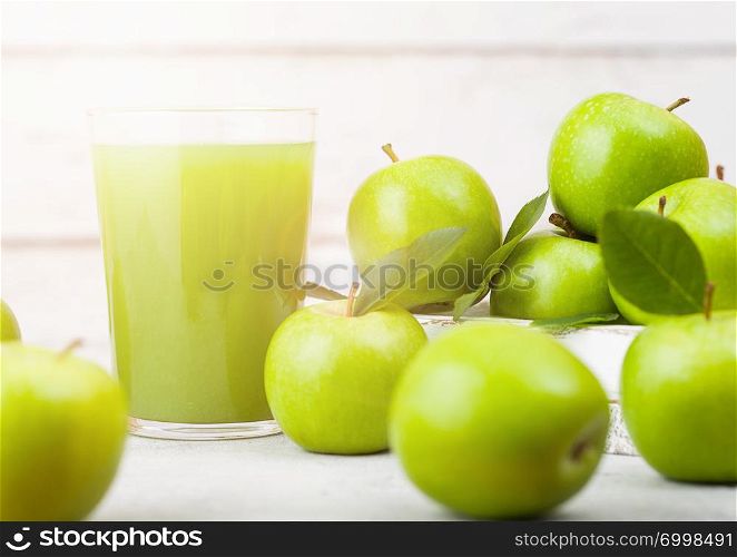 Glass of fresh organic apple juice with healthy green apples in box on wooden background. Space for text