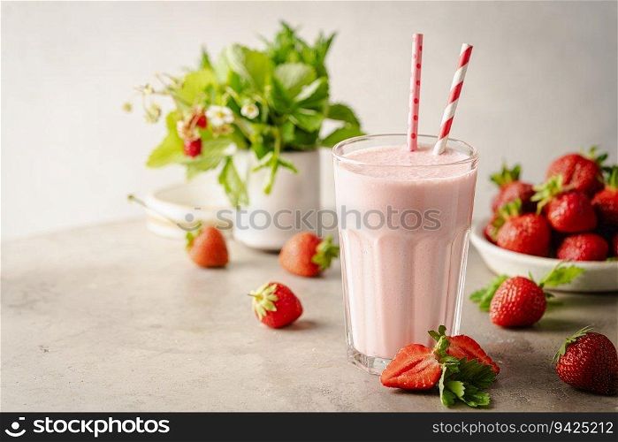 Glass of fresh strawberry milkshake, smoothie and fresh strawberries on light background. Healthy food and drink concept.. Glass of fresh strawberry milkshake