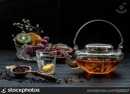 Glass of freshly brewed fruit and herbal tea. Darker background.