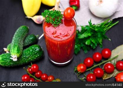 glass of freshly squeezed tomato juice on a table with vegetables, top view