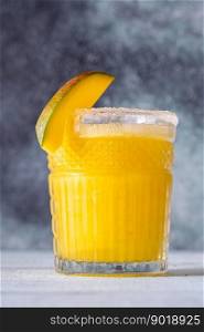 Glass of Frozen Mango Margarita cocktail garnished with mango slice