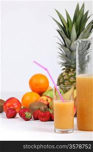 glass of fruit juice with in fruits in background